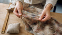 Des mains caressent un tissu ancien pour en apprécier la qualité.