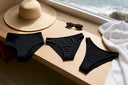 Three bikini bottoms laid flat in natural light
