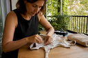 Manos remendando tela transparente de traje de baño