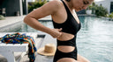 Femme ajustant son maillot de bain noir