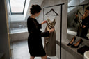 Femme ajustant une robe de cocktail en satin dans la cabine d’essayage