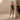 Model wearing a silver sequin crop top and skirt set with thin straps, statement earrings, studio background.