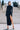 Front view of the Room 24 007 black maxi dress with a high neckline, fitted long sleeves, integrated gloves and thigh-high split.