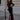 Front view of the Room 24 Verper black velvet maxi dress with one long sleeve, sweeping mesh cut-outs and a thigh-high split.