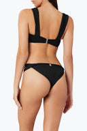 Back view of the Room 24 Camilla black swimsuit showing its strap construction, high-cut legs and sculpted close fit.