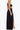 Side view of the Room 24 Joanna black maxi dress highlighting its curved waist cut-outs, body-contouring fit and high leg split.