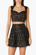 Front view of the Room 24 Isadora mini skirt with textured jacquard fabric, a high-rise waist and structured pleats.