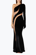 Front view of the Room 24 Verper black velvet maxi dress with one long sleeve, sweeping mesh cut-outs and a thigh-high split.