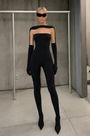 Front view of the Room 24 Janet black catsuit with a boat neckline, sheer illusion-tulle panels and matching long gloves.