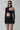 Front view of the Room 24 Bridget black asymmetric bodysuit with a high neckline, curved waist cut-out and glove sleeves.