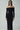 Woman wearing off-shoulder black long sleeve maxi dress with sunglasses and silver bangles