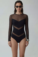 Front view of the Room 24 Milan black shaper bodysuit with sheer long sleeves and geometric chevron panels.