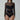 Woman wearing black mesh long sleeve bodysuit with sheer cut-out panels, fashion jewelry
