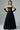 Woman wearing black strapless corset evening gown with lace detailing and long gloves