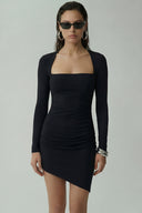 Front view of the Room 24 Jessica black mini dress with a square neckline, long sleeves and asymmetric draped hem.