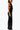 Woman wearing a black sequin cut-out evening gown with a deep v-neck and open sides