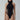 Woman wearing black sustainable bodysuit with mesh side panels and high neckline, fashion pose