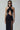 Front view of the Room 24 Astrid black cut-out dress with a crossover halterneck, ruched skirt and thigh-high split.
