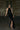 Woman in black sequin halter dress with thigh-high slit, wearing sunglasses and heels