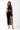 Front view of the Room 24 Iris black sequin lace maxi dress with a crossover halterneck, waist cut-out and thigh slit.