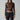 Woman in bronze long sleeve top and black leather pants with sunglasses and silver jewelry