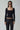 Woman in black square-neck long sleeve top and black leather pants, wearing sunglasses