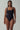 Woman wearing black sustainable one-piece swimsuit with square neckline