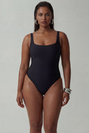 Front view of the Room 24 Ariel black sleeveless bodysuit with a square neckline, wide straps and sculpted close fit.
