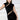 Woman wearing black velvet mini dress with cut-out details and gold earrings
