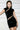 Woman wearing black velvet mini dress with cut-out details and gold earrings