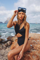 Side view of the Room 24 Alina black one-piece highlighting its curved waist cut-outs and high-cut leg.
