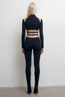 Back view of the Room 24 Anna black catsuit showing its cut-out shoulders, horizontal waist straps and fitted full-length legs.