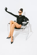 Side view of the Room 24 Jane black bodysuit showing its open-back design, fitted sleeves and tonal leopard finish.