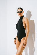 Side view of the Room 24 Lea one-piece swimsuit highlighting its smooth stretch fabric and body-contouring silhouette.