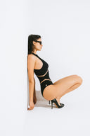 Side view of the Room 24 Maya one-piece highlighting its illusion-mesh waist panels and body-contouring fit.