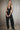 Front view of the Room 24 Denise black plunge halterneck bodysuit with an underwired bust, open sides and high-cut legs.