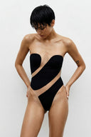 Front view of the Room 24 Eva black strapless bodysuit with sculpted opaque panels and asymmetric sheer mesh cut-outs.