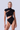 Front view of the Room 24 Clara black bodysuit with a high neck, cap sleeves and diagonal draped cut-outs.