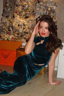 Side view of the Room 24 Isabel emerald maxi dress showing its sculpted velvet fit, waist cut-outs and open-back design.