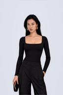 Front view of the Room 24 Gina black asymmetric bodysuit with a chain-trimmed cut-out, halterneck strap and single glove sleeve.