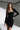 Front view of the Room 24 Jessica black mini dress with a square neckline, long sleeves and asymmetric draped hem.