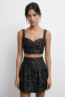 Front view of the Room 24 Isadora mini skirt with textured jacquard fabric, a high-rise waist and structured pleats.