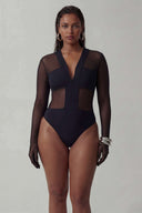 Front view of the Room 24 Maria black mesh bodysuit with sheer long sleeves, opaque bust panels and a central zip.
