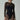 Woman wearing sheer long sleeve black bodysuit with mesh cut-outs and sunglasses