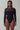 Front view of the Room 24 Melis bodysuit with long mesh sleeves, a sheer shoulder panel and curved waist detailing.