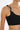Black crop top with braided pink and black shoulder straps, close-up view