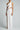 Woman wearing a white one-shoulder sustainable cut-out maxi dress with thigh slit