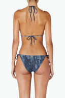 Back view of woman in blue marble print tie bikini set with gold accents