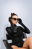 Side view of the Room 24 Jane black bodysuit showing its open-back design, fitted sleeves and tonal leopard finish.
