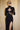 Front view of the Room 24 Talia black corset maxi dress with a mesh-panelled bodice, integrated gloves and thigh-high split.